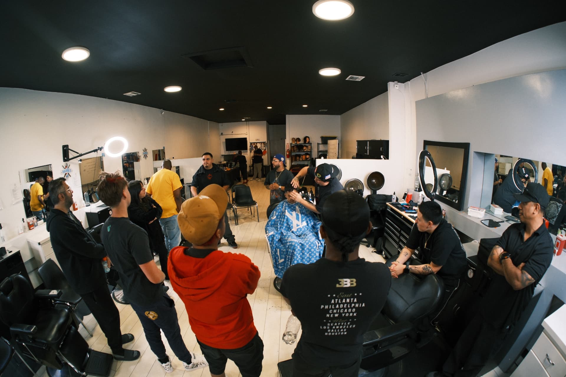 Barbering students gathered around a chair during a demonstration