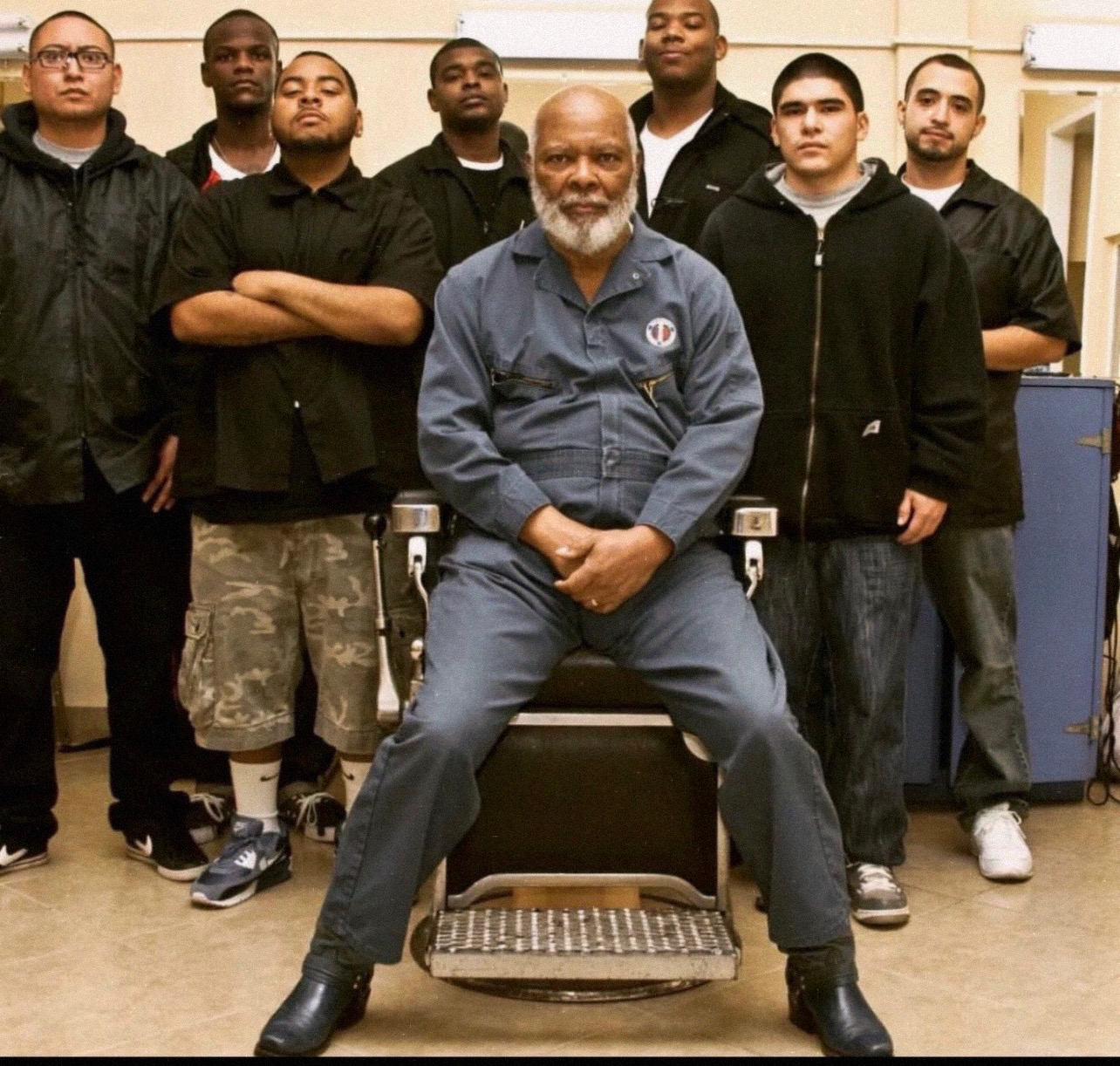 Arthur Borner seated in a barber chair surrounded by students